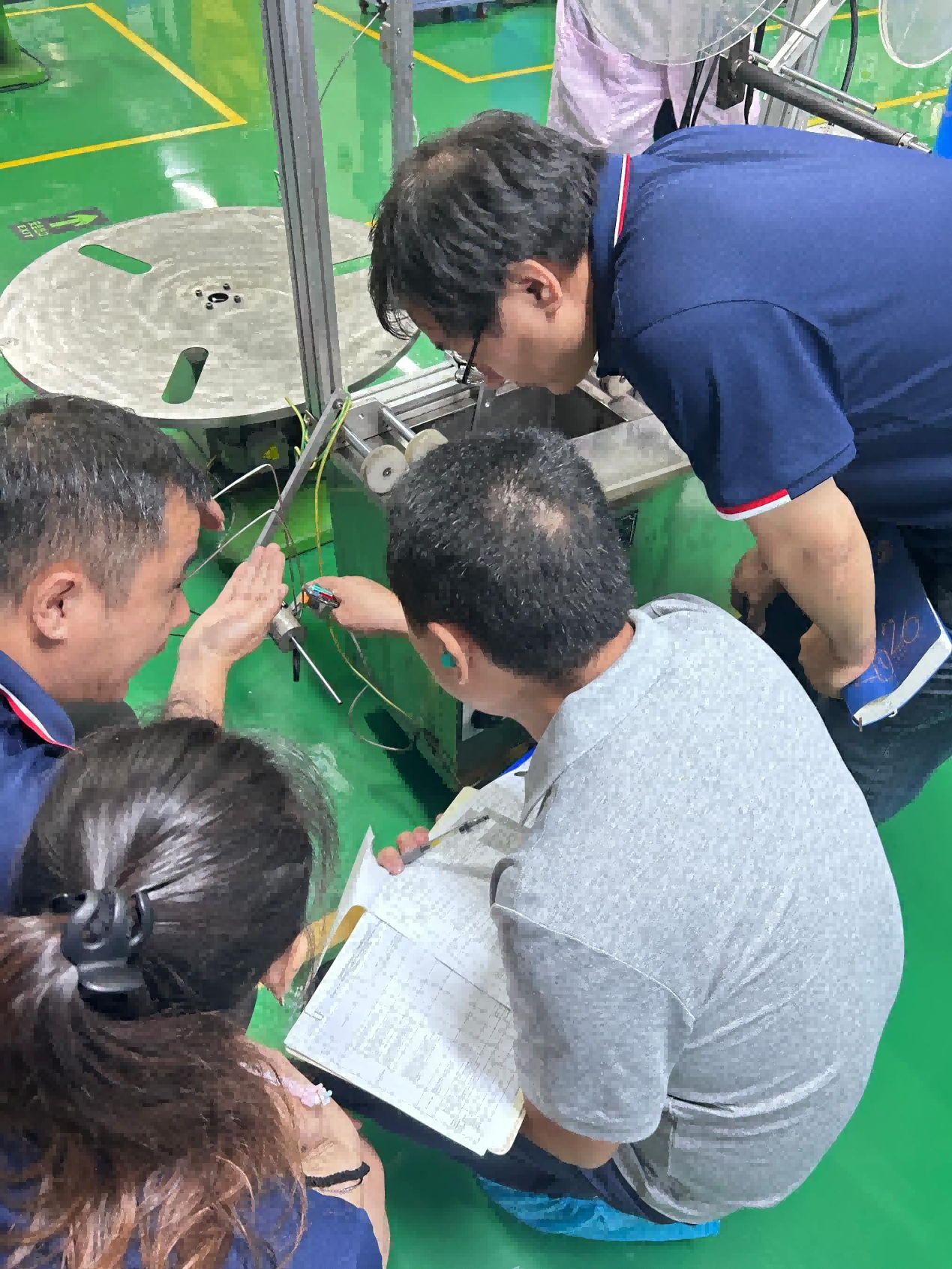 Discussing process details and supporting documentation on the production floor.